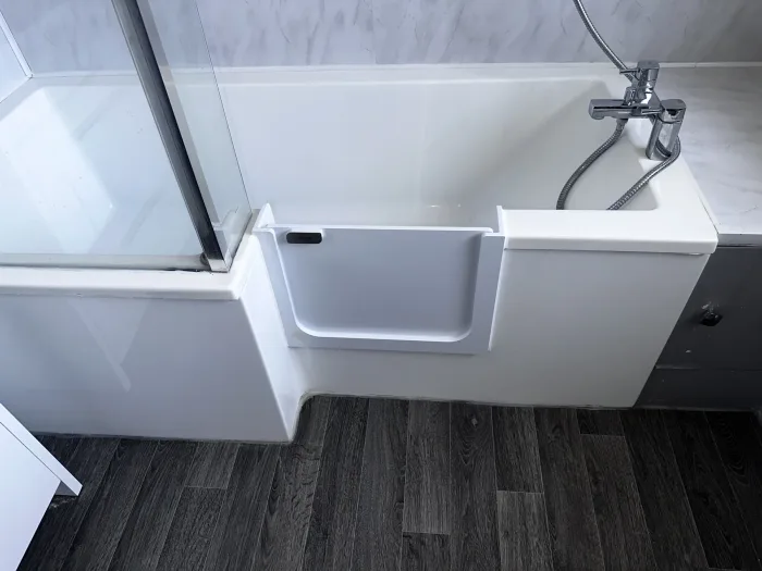 A UDOOR® door fitted into an L-shaped shower bath